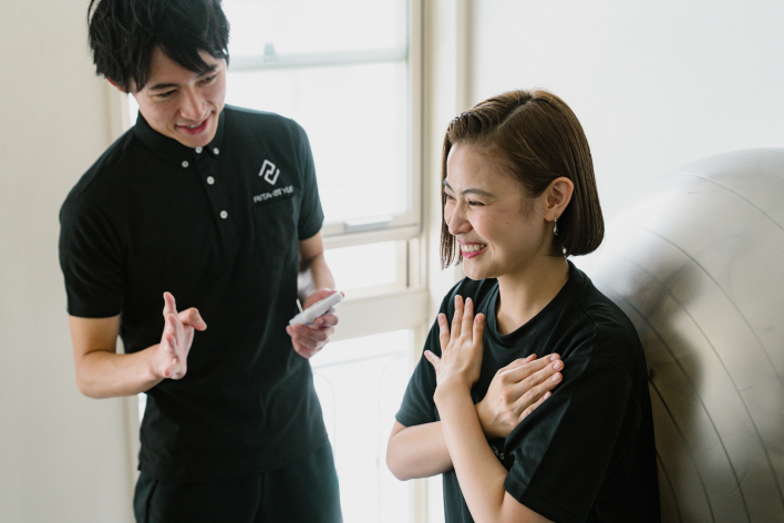 トレーニングをする女性と見守るトレーナー